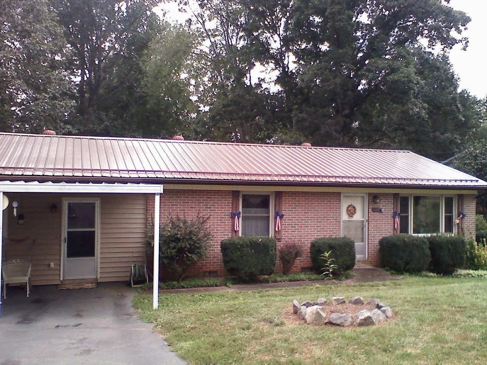 Bronze metal roof and carport on a brick ranch home — Roof Repair work by our crew in Mount Olivet